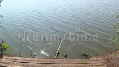 在炎热的夏日里，池塘里的钓竿等待着鱼咬人